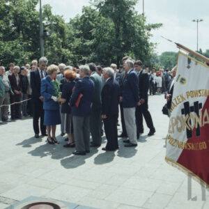 liczna grupa elegancko ubranych osób stojących na placu