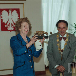 starsza kobieta i starszy mężczyzna w eleganckich ubraniach, kobieta pozuje do fotografii trzymając w rękach statuetkę