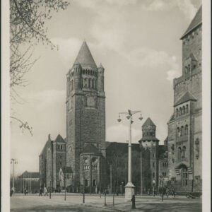 fragment potężnego zamku z górująca wieżą zegarową, po lewej u dołu fragment ulicy z latarnią