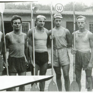 sześciu mężczyzn w średnim wieku, ubranych w stroje sportowe i trzymających w dłoniach wiosła