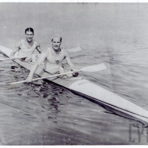 dwaj mężczyźni w średnim wieku płynący w kajaku, każdy z nich trzyma wiosło