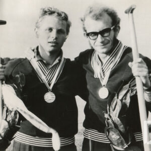 dwóch mężczyzn w dresach prezentujących medale na szyi