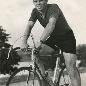 mężczyzna w stroju sportowym, siedzący i pozujący do fotografii na rowerze