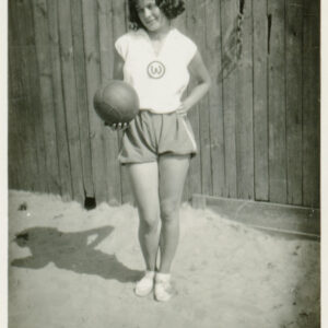 młoda kobieta w stroju sportowym pozująca do fotografii z piłką do koszykówki w rękach