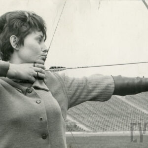 kobieta w stroju sportowym mierząca do celu z łuku