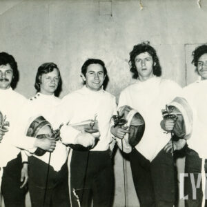 pięciu mężczyzn stojących w rzędzie, ubranych w stroje szermiercze, wszyscy w dłoniach trzymają florety i maski szermiercze