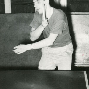 mężczyzna w średnim wieku uderzający rakietką nadlatującą piłeczkę pingpongową