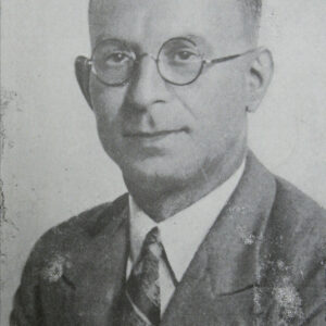 mężczyzna w średnim wieku w okularach, ubrany w garnitur, koszulą i krawat