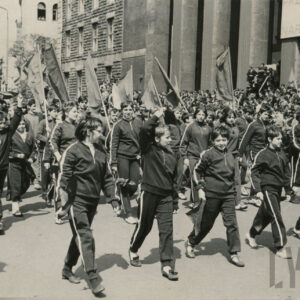 grupa dzieci w klubowych strojach sportowych maszerująca ulicą