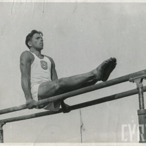 wysportowany mężczyzna wykonujący ćwiczenia gimnastyczne trzymają się rękoma drewnianych poręczy 