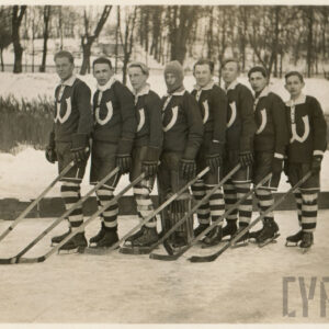 grupa mężczyzn stojących w rzędzie na lodowisku, ubranych w stroje do gry w hokeja na lodzie