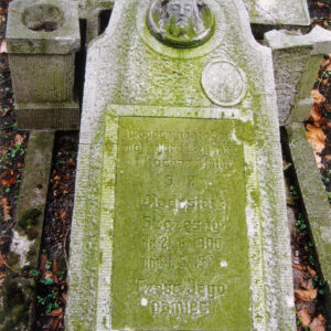 omszała płyta nagrobna o porowatej fakturze z tablicą epitafijną , płaskorzeźbą głowy Chrystusa i śladem po medalionie portretowym 