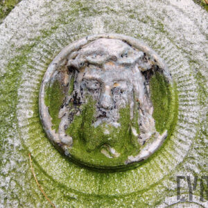 płaskorzeźba głowy Chrystusa w koronie cierniowej umieszczona w żłobkowanym obramowaniu, twarz okolona długimi włosami, broda, zamknięte oczy