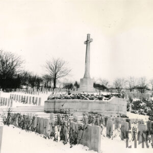 Rzędy jednakowych, pionowych płyt nagrobnych z krzyżem pośrodku. Teren pokryty śniegiem. Z tyłu drzewa bez liści.