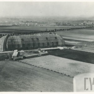 duża drewniana, wrzecionowata konstrukcja otoczona polami