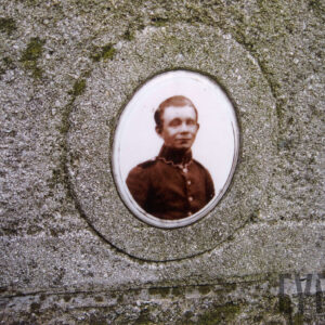 owalny, ceramiczny medalion w kolorze sepii z wizerunkiem mężczyzny w mundurze wtopiony w płytę nagrobną