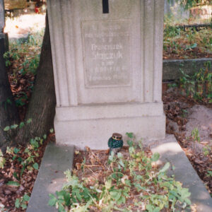 obmurowanie mogiły ziemnej i pionowa płyta nagrobna na cokole z tablicą epitafijną i czarnym krzyżem łacińskim