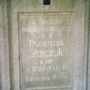 prostokątna tablica z wyrytymi napisami wtopiona w płytę nagrobną