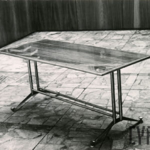 podłużny, lakierowany, drewniany stół na metalowym stelażu stojący na podłodze z płytek imitujących marmur