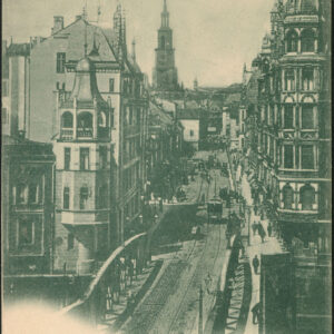 fragment mostu z żelaznymi przęsłami przechodzącego w ulicę, na jej narożnikach i wzdłuż niej okazałe ozdobne kamienice; w głębi wysoka wieża