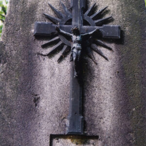 fragment nagrobka w kształcie obelisku, na którym umocowano krzyż łaciński