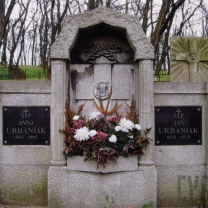 nagrobek w formie tryptyku, w środkowej części nisza z krzyżem łacińskim, po bokach szklane, czarne tablice z inskrypcjami