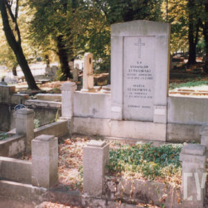 duży grobowiec złożony z wysokiej steli i dwóch niższych płyt po bokach oraz obmurowania z dekorowanymi słupkami, wokół teren cmentarza, inne nagrobki i drzewa