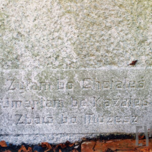 kamienna tablica z wyrytymi napisami wtopiona w płytę nagrobną