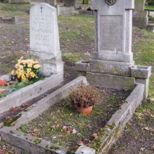 obmurowana mogiła ziemna, w części zagłówkowej wysoka prostokątna płyta na dwustopniowym cokole z płytko wtopionym w nią krzyżem o szerokich ramionach lekko wychodzących poza obrys steli, na przecięciu ramion krzyża okrągły medalion z płaskorzeźbioną głową Chrystusa w koronie cierniowej, w dolnej części krzyża tablica inskrypcyjna, z lewej sąsiedni nagrobek