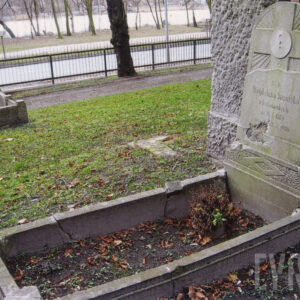 ziemna mogiła otoczona niskim obmurowaniem, w partii zagłówkowej pionowa, prostokątna tablica zamknięta na górze łukiem, osadzona na cokole, w jej dolnej części, odciętej ukośną nieregularną linią na wzór skały, wyryty napis epitafijny, z lewej duży ubytek na licu, w górnej części płaskorzeźbiony krzyż na tle promienistej glorii, na przecięciu ramion krzyża tondo bez medalionu, za grobem trawa, w głębi fragment metalowego ogrodzenia cmentarza