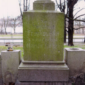 czworoboczny postument osadzony na niskim cokole, w zwieńczeniu profilowany, na szczycie cokolik pod nieistniejący krzyż, lico postumentu wypełnia ryty napis, po bokach czworoboczne słupki jako kwietniki z kolistymi otworami