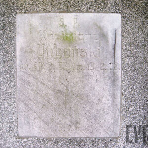 prostokątna, marmurowa tablica z wyrytym na niej napisem, pośrodku, w górnej części zielony nalot