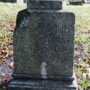 nagrobek w formie czworobocznego postumentu (ubytek na lewej górnej krawędzi) osadzonego na profilowanym, uskokowym cokole, powyżej w zwieńczeniu  cokolik, na awersie i rewersie postumentu wyryty napis, nagrobek otoczony zaniedbanym trawnikiem i suchymi liśćmi