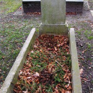 ziemna mogiła z murowanym obramowaniem, w części zagłówkowej prostokątna płyta zamknięta spłaszczonym łukiem, na jej szczycie czworoboczna podstawa pierwotnego krzyża, na płycie wyryty napis, wewnątrz obramowania grobu suche liście i resztki świerkowych gałązek, w głębi murowane groby