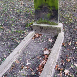 mogiła ziemna w kształcie prostokąta, otoczona niskim obmurowaniem, u wezgłowia płyta w formie stojącego prostokąta zamkniętego łukiem z wyrytym napisem, nad inskrypcją wyryty krzyż łaciński, płyta osadzona na szerokim cokole i pokryta zielonym nalotem