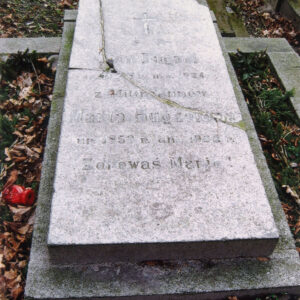 na ziemnej mogile zbliżonej kształtem do kwadratu, obmurowanej, pośrodku leży prostokątna, pęknięta granitowa płyta położona na szerszej podmurówce, na płycie ryty napis i krzyż łaciński wypełnione czarnym barwnikiem