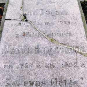 prostokątna, pęknięta i z ubytkami płyta położona poziomo z rytym napisem, powyżej inskrypcji wyryty krzyż łaciński, krzyż i napis wypełnione czarnym barwnikiem