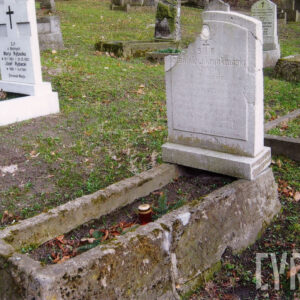 mogiła ziemna otoczona wysokim, popękanym i omszałym obmurowaniem, u wezgłowia stela w formie stojącego prostokąta zakończona zamkniętym łukiem, z lica lekko wystająca tablica z wyrytym napisem, nad inskrypcją ślad po okrągłym medalionie, stela odłamana w lewym górnym narożu, pęknięcia na prawej krawędzi, w głębi kamienna nagrobki