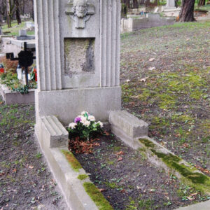 mogiła ziemna otoczona niskim murkiem, pokrytym porostami i mchem, wzdłuż dłuższych boków dwa odcinki żłobkowanych niskich murków, u wezgłowia stela osadzona na wysokim cokole, pośrodku gładka płyta, po jej bokach dwa niższe żłobkowane skrzydła, na płycie ślad po brakującej tablicy inskrypcyjnej, nad nim płaskorzeźbiona głowa Chrystusa na tle krzyża