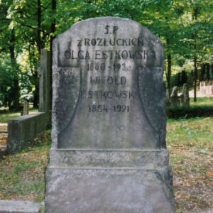 nieregularnie obrobiony blok kamienny zamknięty łukiem, umieszczony na prostopadłościennej podstawie, na bloku wypukło rzeźbiony, wychodzący lekko przed lico, gładki krzyż o belce poprzecznej przechodzącej w łuk z dolną belką rozszerzająca się, na krzyżu ryta inskrypcja