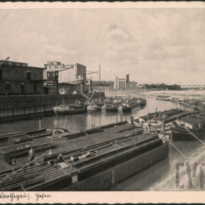 barki zacumowane na obu brzegach rzeki, z lewej budynki magazynowe i żurawie portowe, w głębi wysoki przemysłowy budynek