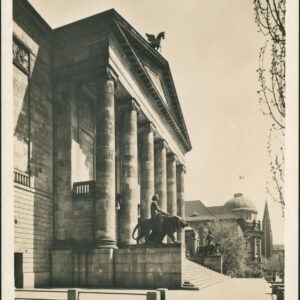 wejście do budynku z jednym rzędem sześciu kolumn, które wspierają trójkątny dach, na nim rzeźba konia ze skrzydłami, do budynku prowadzą szerokie schody, po obu ich stronach rzeźby, w głębi fragment budynku z półokrągłym ryzalitem zwieńczonym kopułą
