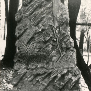 kamienna stela w formie nieregularnego kopca skalnego o chropowatej powierzchni i ukośnych nacięciach, z bryły kopca wyodrębniono krzyż łacińskich o gładkich ramionach, na steli motywy roślinne paproci ( u dołu, z lewej) i gałązki dębowej (pod krzyżem)