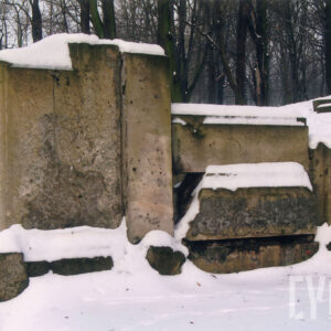 boczna. lewa część dużego murowanego, silnie uszkodzonego nagrobka z  wysokimi płycinami i prostopadłościennymi kolumnami w narożach, nagrobek niesymetryczny, sceneria zimowa