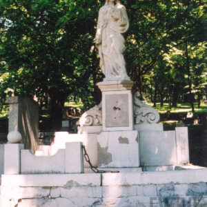 grobowiec na wysokiej otynkowanej podmurówce, na cokole okalającym mogiłę prostopadłościenne słupki zwieńczone kulami, pomiędzy nimi prostokątne, wklęsłe od góry płyciny, w części zagłówkowej trójosiowa stela w formie wydłużonego prostokąta, na części środkowej postument, na nim figura mężczyzny z gorejącym sercem na piersi i ręką wskazującą na nie, ślady łańcucha łączącego pierwotnie słupki na nagrobku