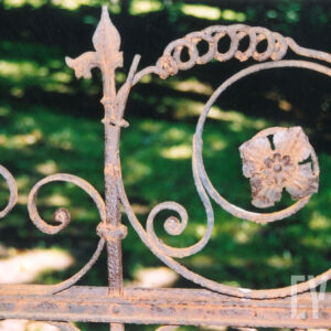 fragment skorodowanej karty grobowca z motywami zakręconych linii i elementów kwiatowych