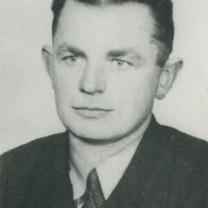 mężczyzna w średnim wieku, ubrany w koszulę, krawat i marynarkę, pozujący do fotografii