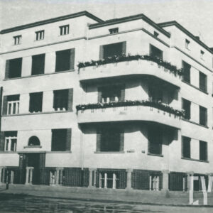 kilkupiętrowy budynek z balkonami przy skrzyżowaniu ulic