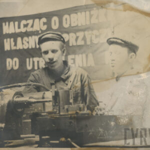 dwaj młodzi mężczyźni w stroju roboczym, stojący przy urządzeniu mechanicznym