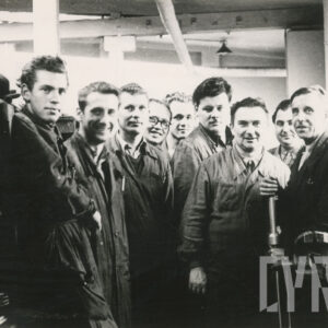 grupa mężczyzn w średnim wieku w ubraniach roboczych pozująca do fotografii